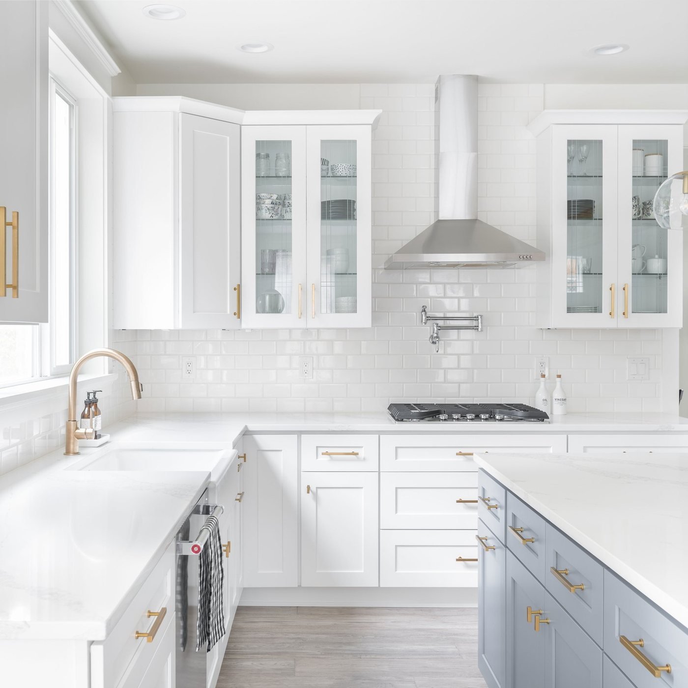 L shaped white kitchen with brass hardware