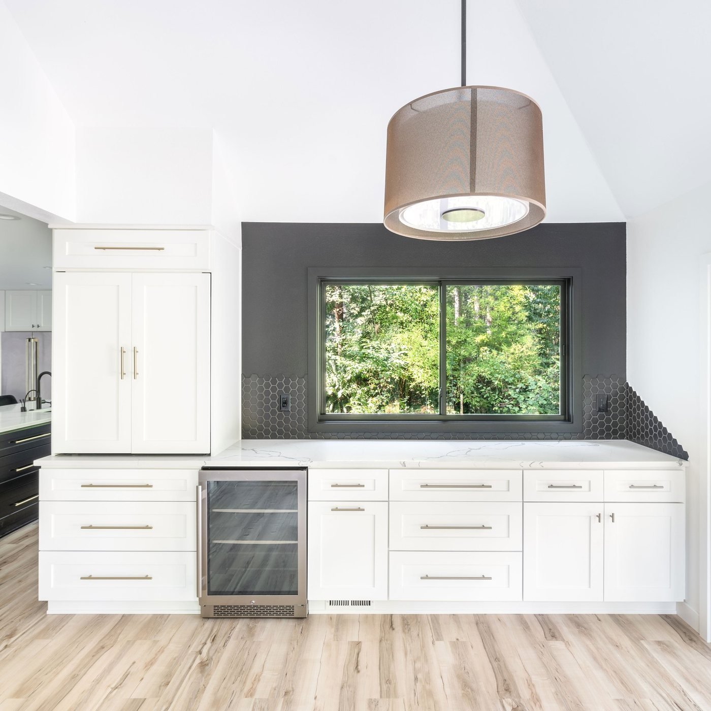 Dark cabinet kitchen with a window and beverage fridge