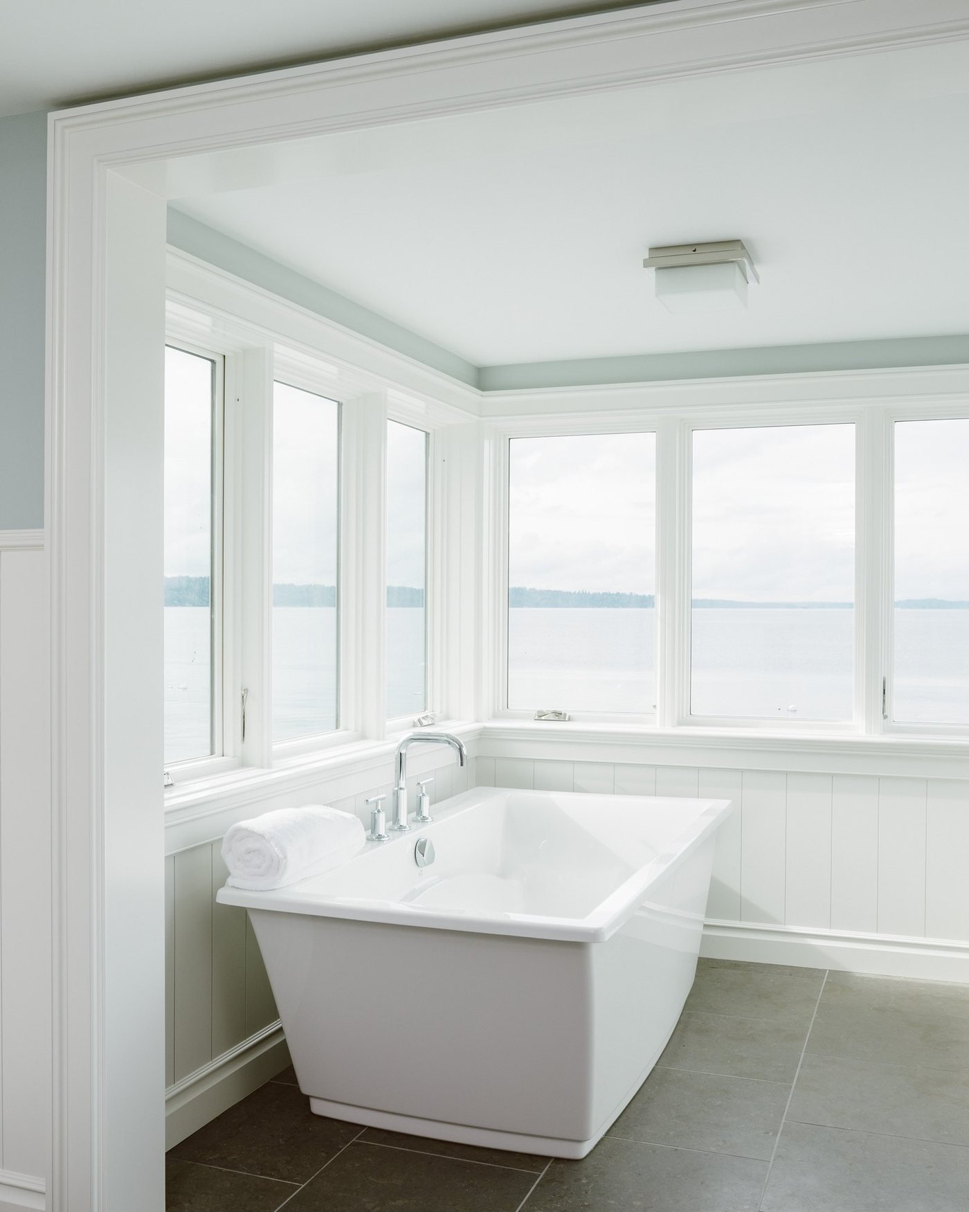Spa style bathroom with a freestanding tub by a window