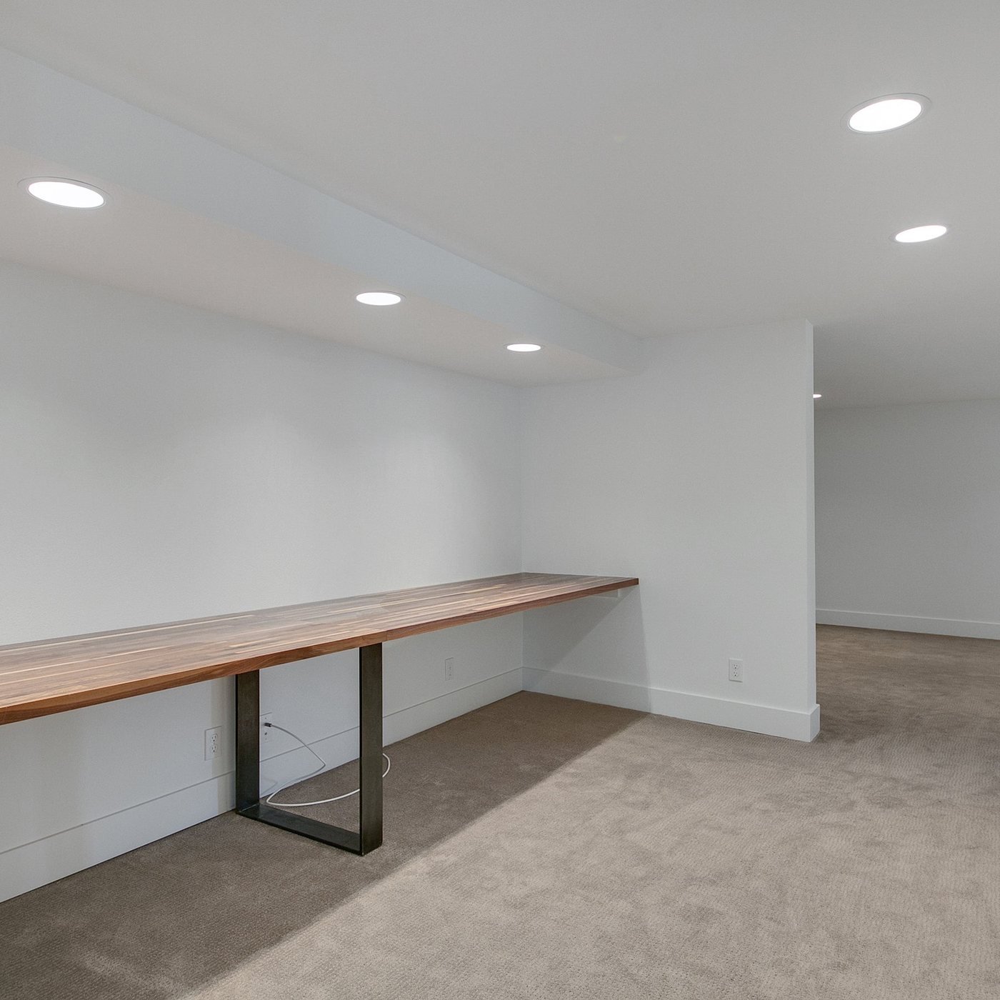 Finished basement office with a long built-in desk