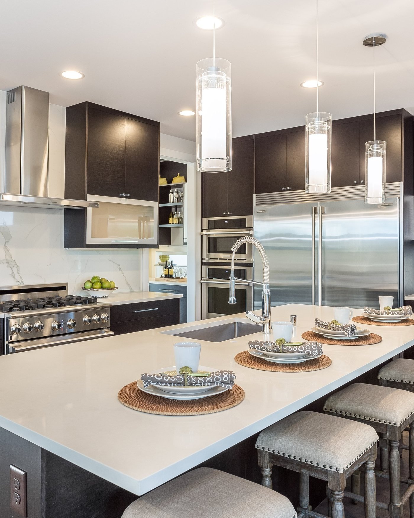 Modern kitchen remodel with a dark island and waterfall quartz counter